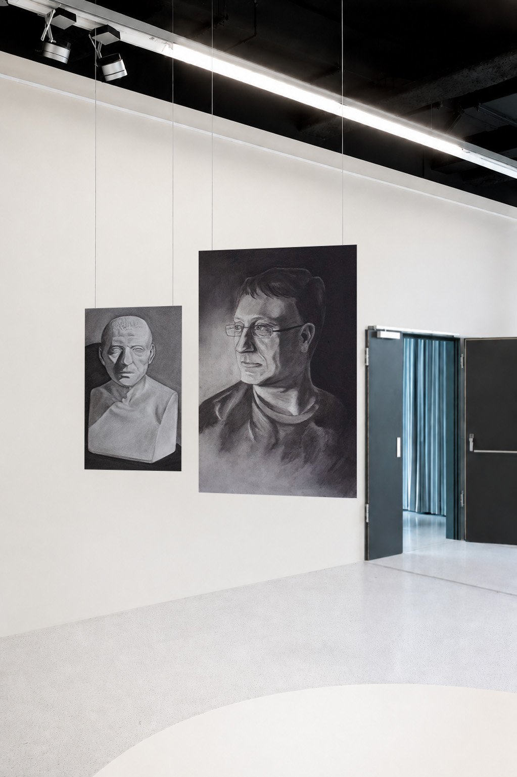 Two charcoal studies — a master study of a Cicero bust and a portrait of the artist's father wearing glasses — hanging by wires in a gallery space